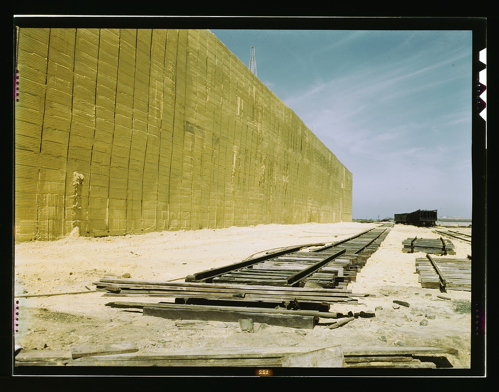 A long wall of stored sulphur beside railroad track, 1943